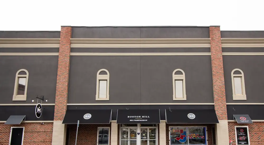 Front entrance of building with NewBrick brick and brown Dryvit Outsulation.